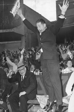 Melbourne coach Norm Smith leaps with joy after Melbourne wins the 1964 grand final.