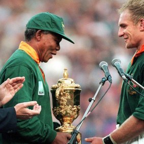 Then South African President Nelson Mandela, wearing a Springboks jersey, congratulates skipper Francois Pienaar after handing him the William Webb Ellis trophy at Ellis Park in Johannesburg in 1995.