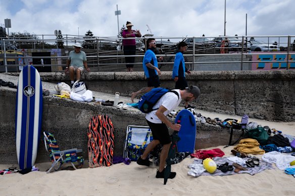 People collecting items left on Bondi Beach. 