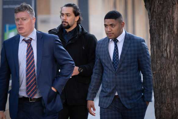 Manase Fainu (right), supported by fellow Manly player Josh Aloiai (centre), outside court last month.