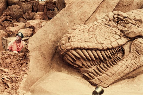 Peter Redmond, at left, with one of his giant sand creations in Australia in 2009. 