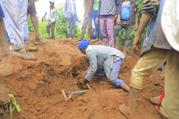 A man searches for survivors hundreds of people gather at the site of a mudslide in the Kencho Shacha Gozdi district, Gofa Zone, southern Ethiopia.