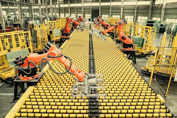A mechanical hand-sheet picking system automatically stacks glass on a factory production line in China in July 2025.