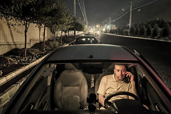 A man waits in line at a petrol station west of Tehran on June 17 as Iranians stockpile amid attacks from Israel.