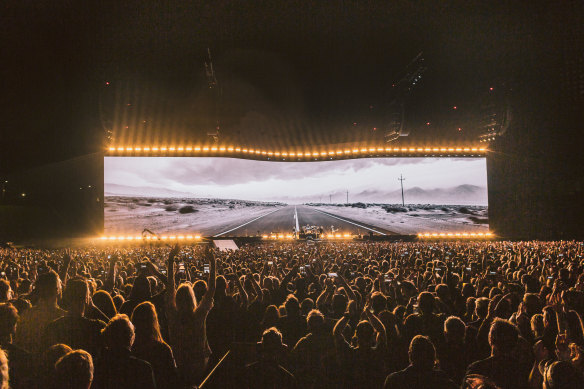 The band is dwarfed by the massive screen, filled with short movies shot by Anton Corbijn.
