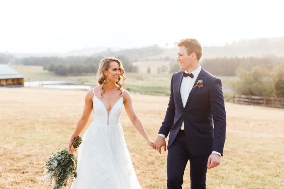 Alissa McGovern and her husband Liam on their wedding day. A thick haze of smoke from nearby bushfires can be seen in the background.