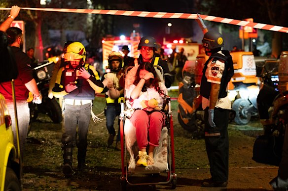 Emergency workers assist civilians after a missile strike in central Tel Aviv, Israel.