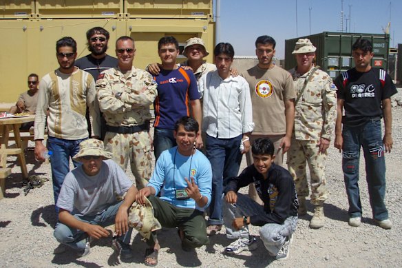 Former military investigator Peter Ensor (centre of back row with bucket hat) served with interpreter Raz Mohammad (second-from-left in back row with sunglasses) in Afghanistan in 2007.