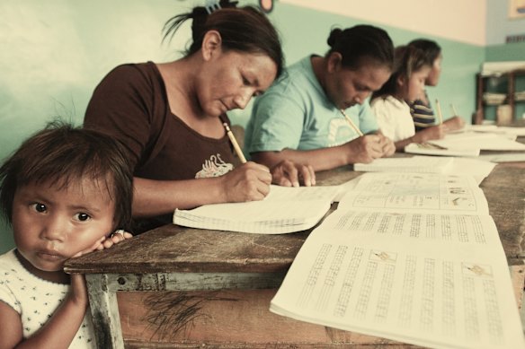 Adult Venezuelans take part in Plan Robinson literacy classes, an initiative of Hugo Chavez, in 2004.