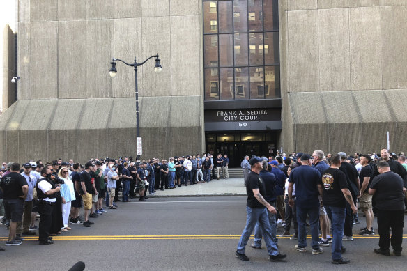 In this photo provided by WKBW, supporters of two suspended Buffalo police officers assemble outside the courthouse in Buffalo.