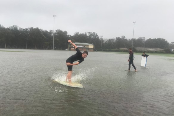 Kids have fun on their boards at flooded Nolan Reserve in Manly on Sunday.