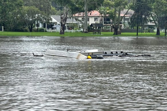 Debris floats away in the Woronora River. 