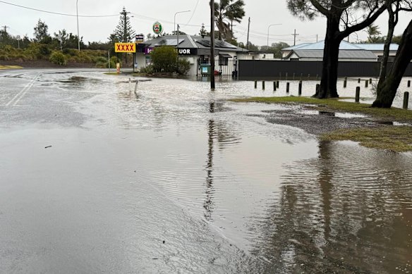 Flooded waters surround a bottle shop in Lake Burrill.