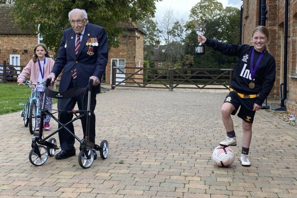 Captain Tom Moore poses for a photo with fellow fundraisers Imogen Papworth-Heidel, right, and Pepa Lorente at his home in Marston Moretaine, England. 