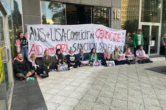 Gaza protesters including newly sworn-in Upper House Greens MP Sophie McNeill (seated fourth from right) blocking the entrance.