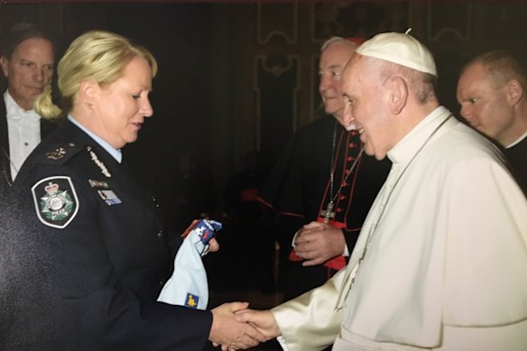 Debbie Platz, while in her role as an assistant commissioner with the Australian Federal Police, meeting Pope Francis who is said to have blessed the Uniforms 4 Kids charity and the outfit held by Platz.