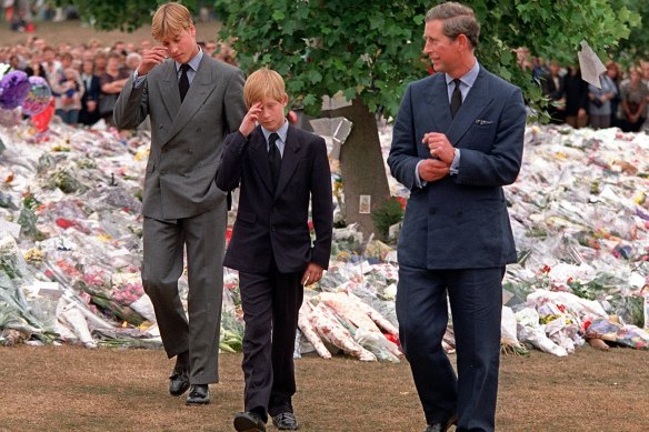 William and Harry are accompanied by Charles as they inspect the flowers placed outside Kensington Palace in memory of Diana