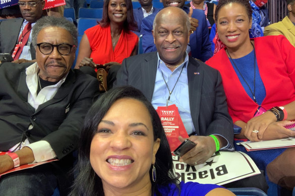 Herman Cain, centre, tweeted this photograph of himself at the Trump rally in Tulsa last month.