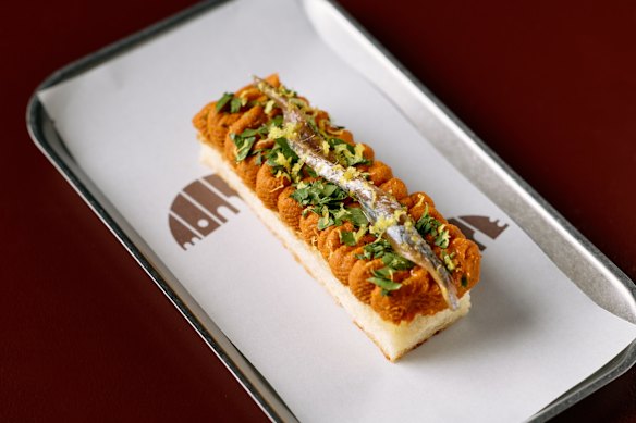 Tostada de anchoa, mantequilla de tomate ahumado y limón.