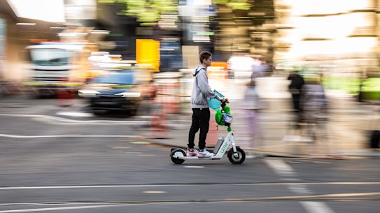 A man rides a e-scooter through Melbourne’s CBD.