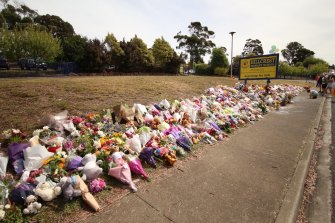 Flowers, plush toys and candles blanket the front lawn of Hillcrest Primary School in Devonport on Friday morning.
