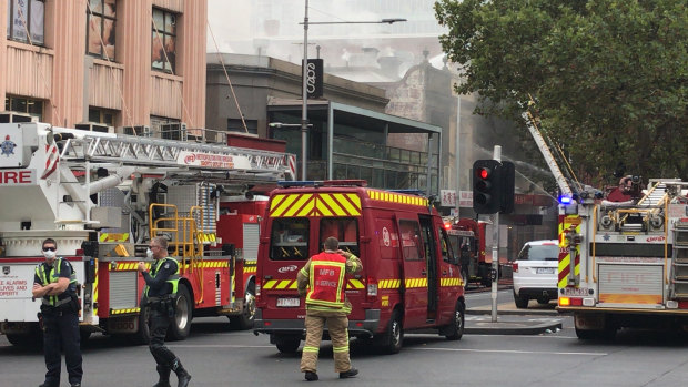 Firefighters and police at the fire on the corner of Russell and Bourke streets.