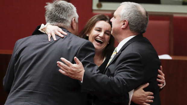 Jacqui Lambie celebrates with fellow crossbench senators Rex Patrick and Stirling Griff after the passage of the tax-cut bill on Thursday night.