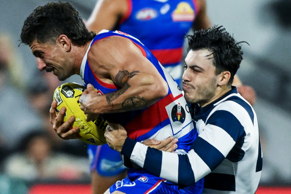Tom Liberatore of the Bulldogs tackled by Brad Close of the Cats.