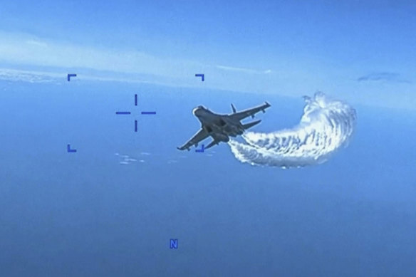 An image the Pentagon says shows a Russian Su-27 approaching the back of the American MQ-9 drone and beginning to release fuel as it passes.