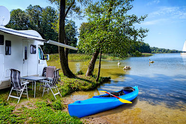 A campervan and kayak set up on the edge of the lake - Sniardwy lake in Poland
