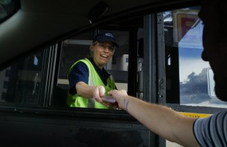 A Sydney Harbour Bridge collector accepts change from a motorist at the toll booth in 2004. 