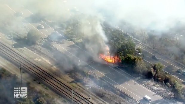 The fire is burning near train tracks, with buses replacing trains.