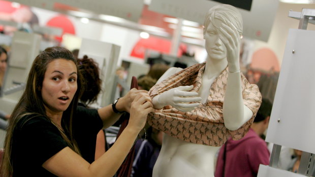 Sold like hotcakes ... a woman strips a mannequin for a Stella McCartney item at Target in 2007.