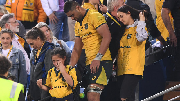 Targeted: Tui leads his young sister down from the stands following the incident. 