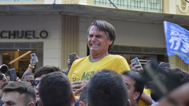 Presidential candidate Jair Bolsonaro grimaces right after being stabbed. 