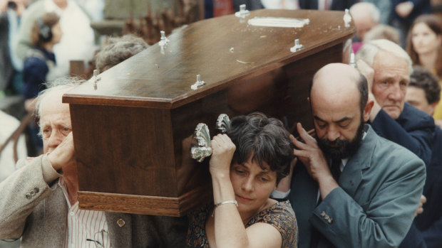 Pall bearers carry the coffin to the Montsalvat hall