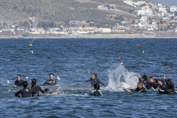 Surfers throw flowers during a tribute to the Australians and American in Ensenada, Mexico.