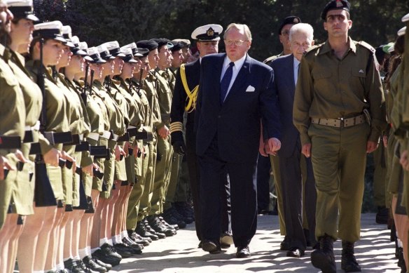 Finnish President Martti Ahtisaari, centre, reviews Israeli troops with Israeli President Ezer Weizman, right, behind soldier, in Jerusalem, 1999. 