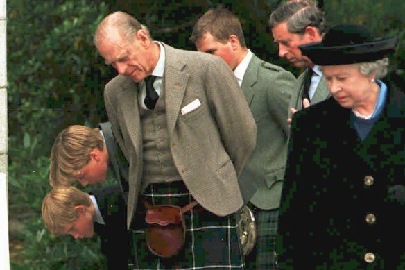 (L-R) Prince Harry, Prince William, Prince Phillip, Peter Phillips, Prince Charles and Queen Elizabeth II look at flowers and cards laid at the gates of Balmoral on September 4, 1997. 