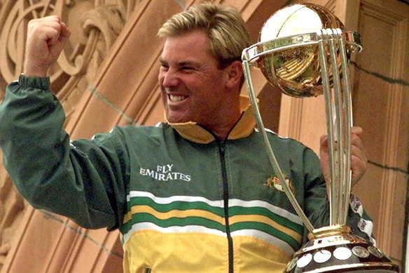 Shane Warne clenches his fist as he holds the Cricket World Cup Trophy in June 1999.