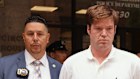 William Duplessie is escorted out of the New York Police 13th Precinct after turning himself in on charges of kidnapping and false imprisonment