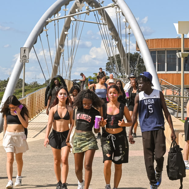 A group of friends cross the Kananook Creek footbridge towards Frankston Pier.