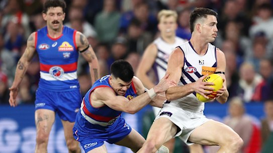 Patrick Voss of the Dockers is tackled by Matthew Kennedy of the Bulldogs during Saturday’s must-win clash.
