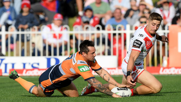 Mitchell Pearce of the Knights scores against the Dragons at Glen Willow Stadium in 2019.