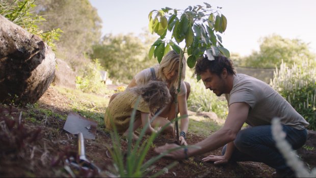 Filmmaker Damon Gameau planting a tree with his wife and daughter.
