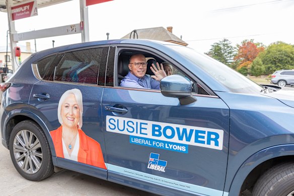 Dutton waves as he leaves the petrol station with candidate Susie Bower.