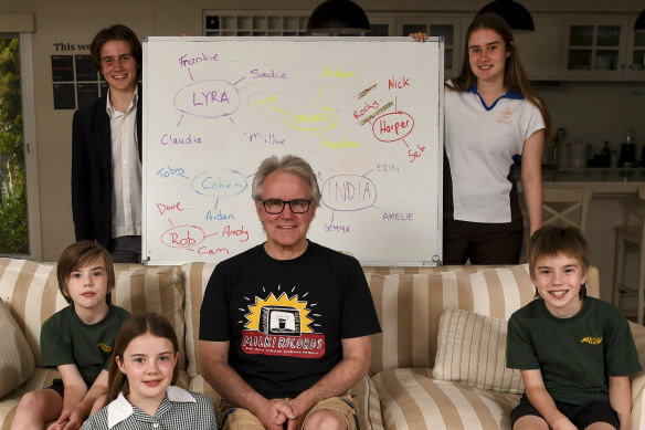 Rob Wallace with his five children and the whiteboard they use to organise their lives.