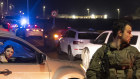 An Israeli soldier secures a road after a drone attack that caused mass casualties near Haifa.  