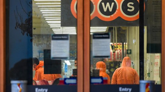 Workers in protective gear prepare to deep clean a Woolworths at Epping Plaza on Tuesday after it was listed as a tier 1 COVID-19 exposure site.
