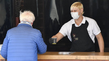 A waiter serves a coffee to go at an ice cream parlour in Gelsenkirchen, Germany.
